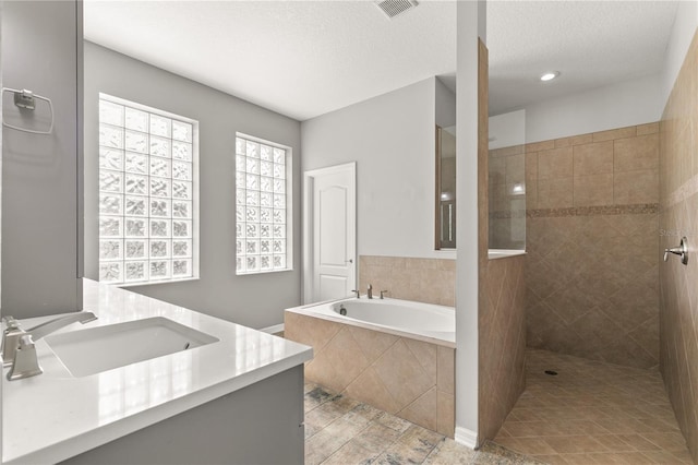 bathroom with vanity, plus walk in shower, tile patterned flooring, and a textured ceiling