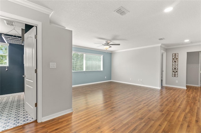 empty room with a textured ceiling, crown molding, hardwood / wood-style floors, and ceiling fan