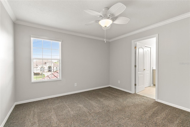 empty room featuring a textured ceiling, ornamental molding, ceiling fan, and light colored carpet