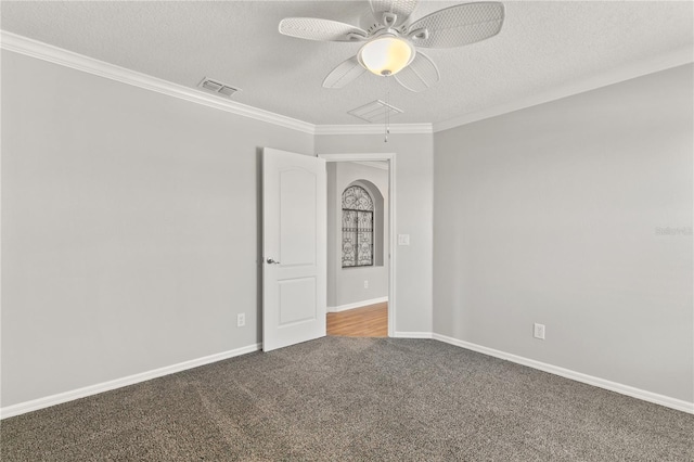 empty room with crown molding, ceiling fan, carpet floors, and a textured ceiling