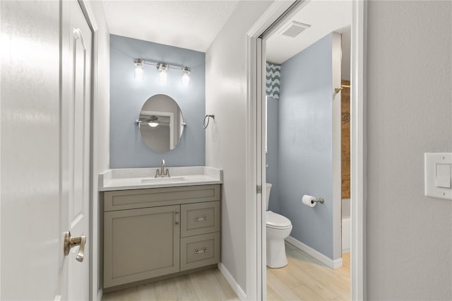 bathroom with curtained shower, hardwood / wood-style floors, vanity, and toilet