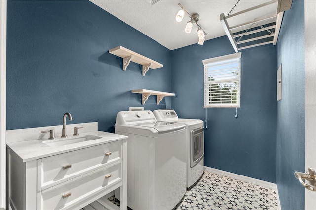 clothes washing area featuring washer and clothes dryer and sink