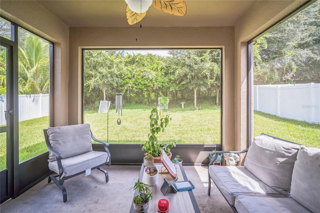 sunroom / solarium featuring a healthy amount of sunlight and ceiling fan