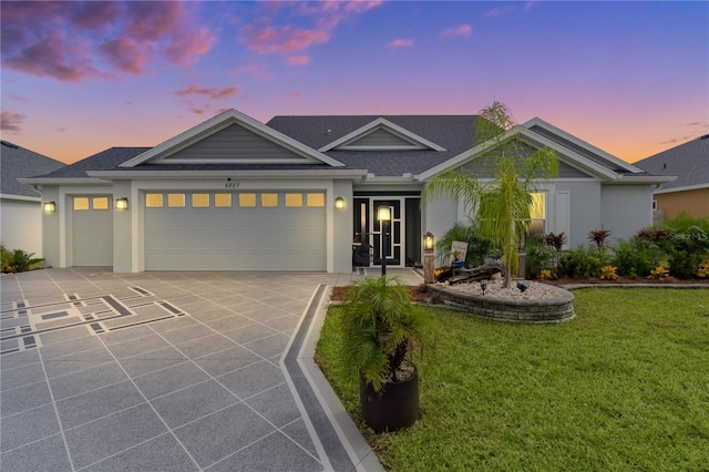 view of front of home featuring a garage and a lawn