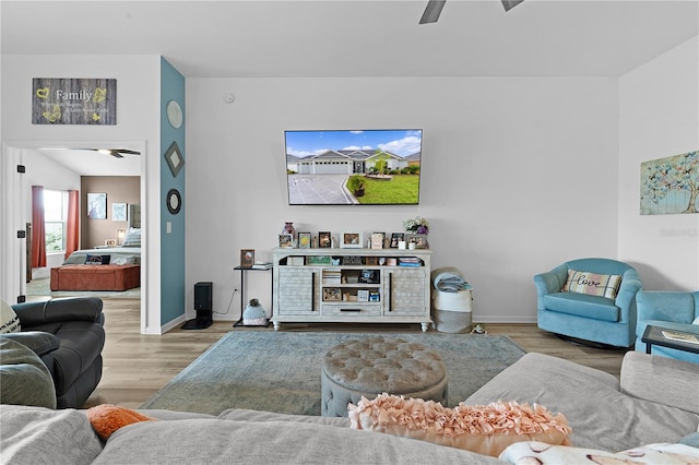 living room with ceiling fan and light wood-type flooring