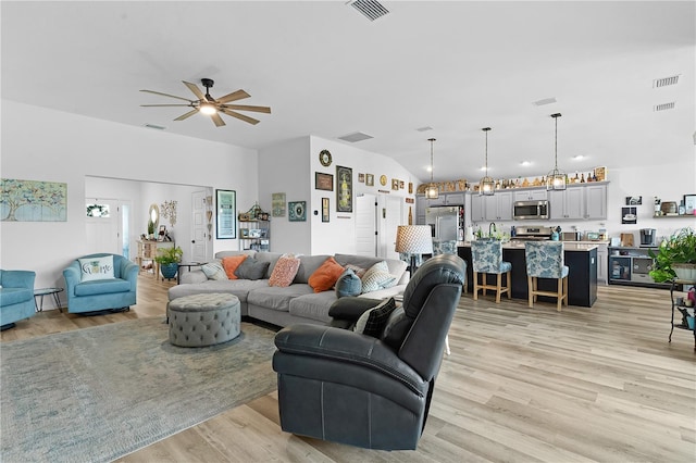 living room featuring vaulted ceiling, ceiling fan, and light hardwood / wood-style floors