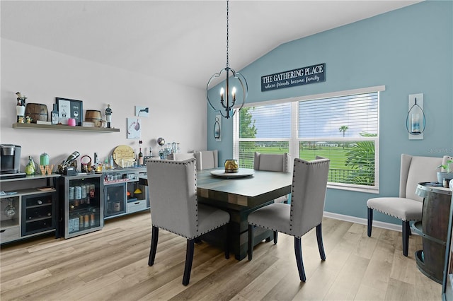 dining room featuring lofted ceiling, wine cooler, light wood-type flooring, and a notable chandelier