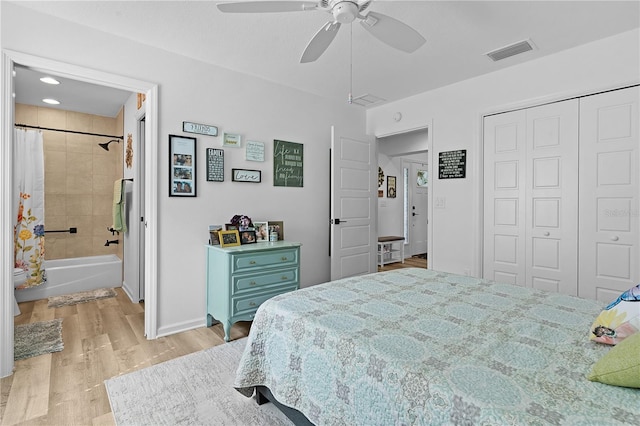 bedroom featuring ceiling fan, a closet, light hardwood / wood-style floors, and ensuite bath