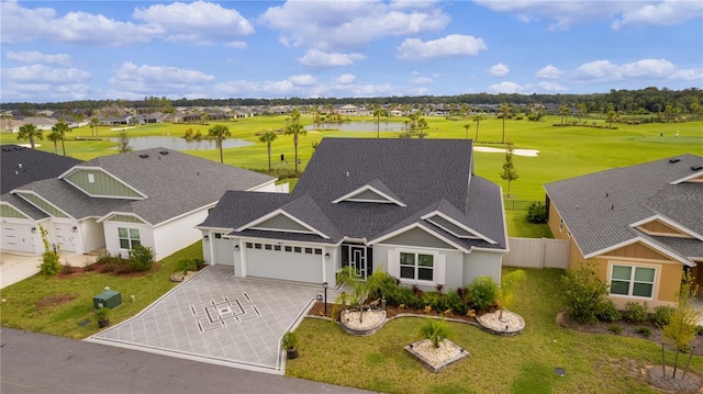 view of front of property with a front lawn, a garage, and a water view