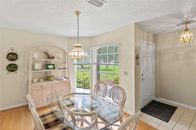 dining room featuring a textured ceiling and hardwood / wood-style floors