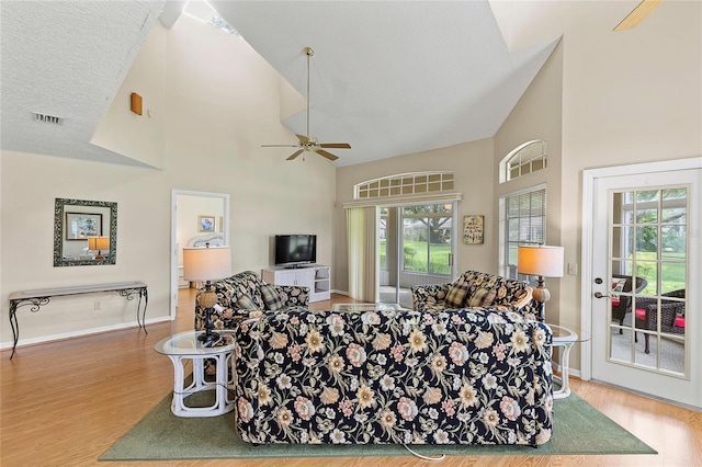 living room featuring visible vents, high vaulted ceiling, a ceiling fan, and wood finished floors