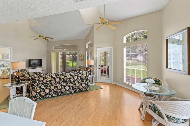 living room with plenty of natural light, ceiling fan, and light hardwood / wood-style floors