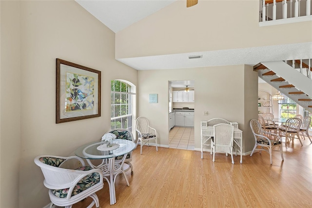 dining area with visible vents, ceiling fan, baseboards, stairs, and light wood-style floors