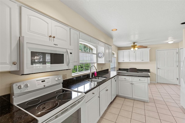 kitchen with light tile patterned floors, white appliances, white cabinetry, sink, and ceiling fan