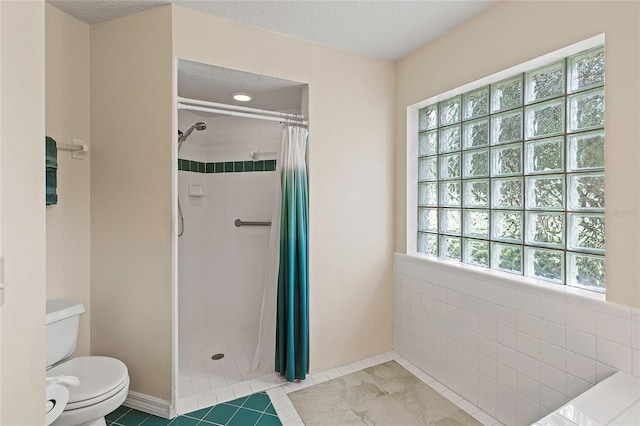 full bath featuring tiled shower, toilet, tile patterned flooring, and a textured ceiling