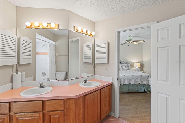 bathroom featuring toilet, hardwood / wood-style floors, vanity, a textured ceiling, and ceiling fan