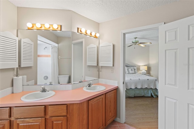 bathroom with a sink, a textured ceiling, a ceiling fan, and toilet