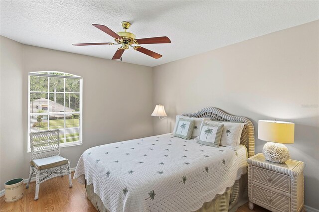 bedroom featuring a textured ceiling, ceiling fan, and hardwood / wood-style flooring