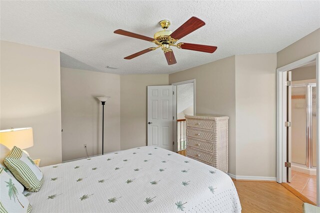 bedroom featuring light wood-type flooring, a textured ceiling, and ceiling fan