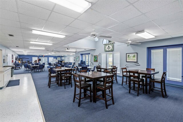 dining room with ceiling fan and a drop ceiling