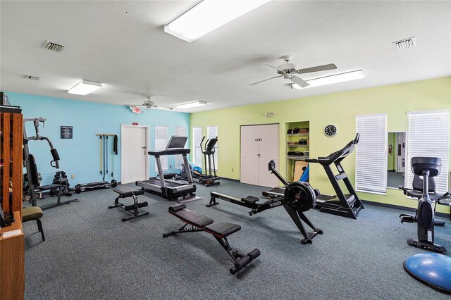 exercise room featuring ceiling fan and a textured ceiling