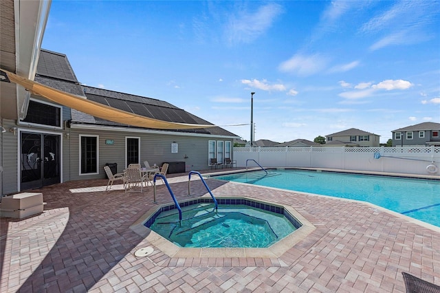 view of swimming pool featuring a fenced in pool, an in ground hot tub, a fenced backyard, and a patio area