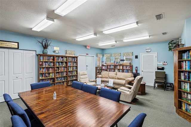 dining room featuring visible vents, carpet, and a textured ceiling