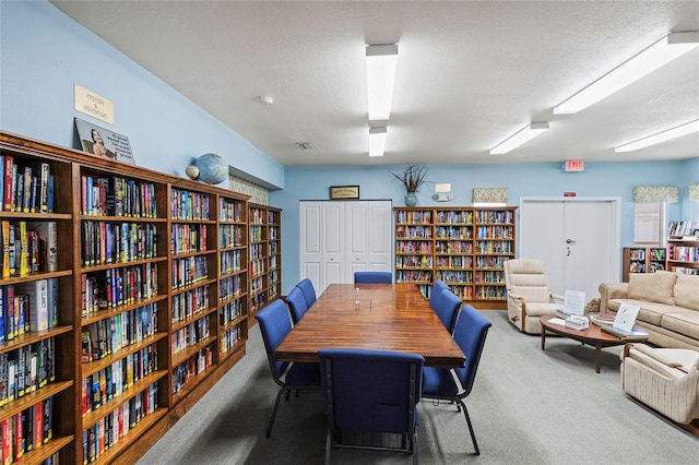 carpeted dining space with a textured ceiling