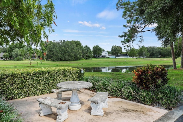 exterior space featuring a patio, a lawn, and a water view