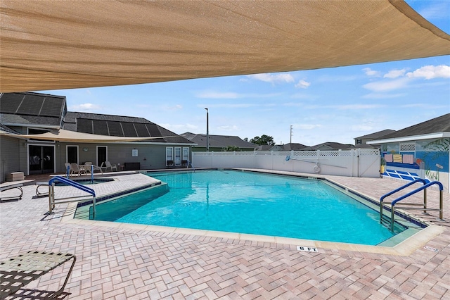 community pool with a fenced backyard and a patio