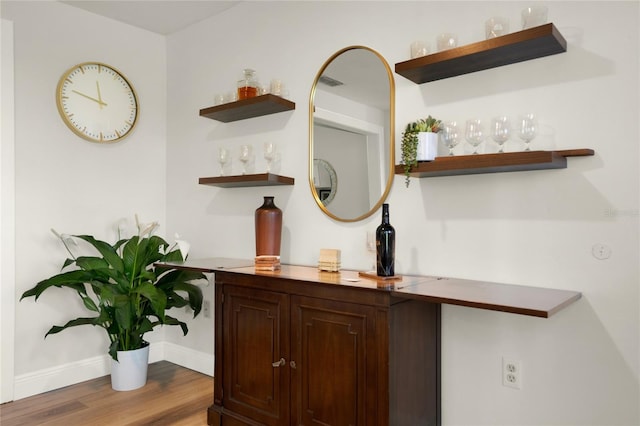 room details with hardwood / wood-style flooring and indoor bar