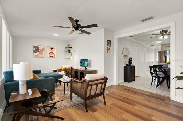 living room featuring light wood-type flooring, ceiling fan, and a wealth of natural light