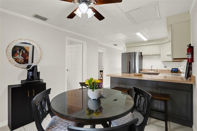 tiled dining room with sink and ceiling fan