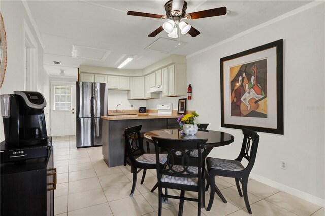 dining area featuring ceiling fan, sink, and light tile patterned flooring