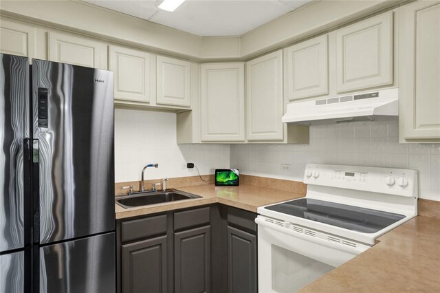 kitchen with gray cabinetry, stainless steel fridge with ice dispenser, sink, decorative backsplash, and white range with electric cooktop