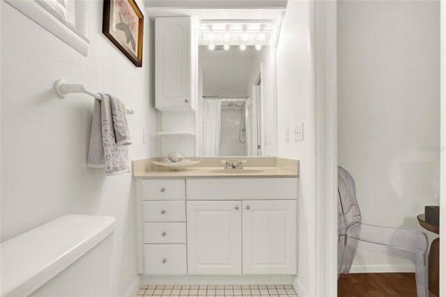 bathroom featuring vanity, toilet, curtained shower, and tile patterned flooring