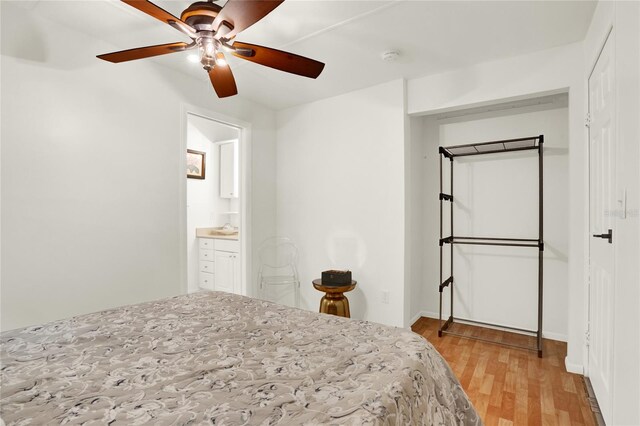 bedroom with ensuite bath, light hardwood / wood-style flooring, ceiling fan, and a closet