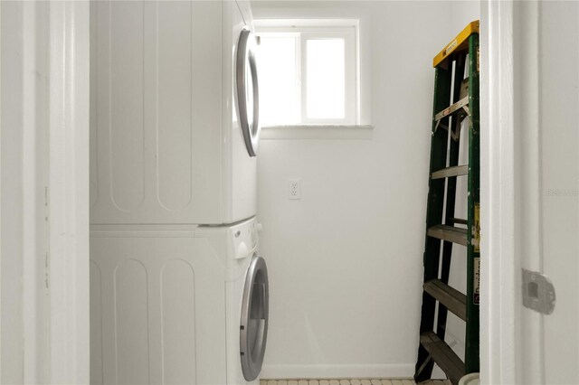 clothes washing area with stacked washer / dryer