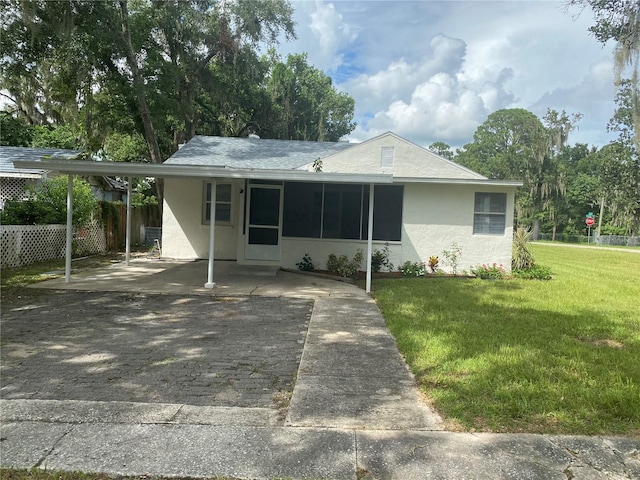 ranch-style house with a front yard and a carport