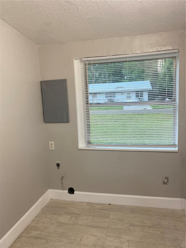 clothes washing area featuring a textured ceiling, wood-type flooring, and hookup for an electric dryer