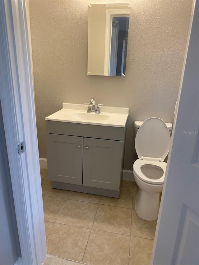 bathroom featuring tile patterned flooring, vanity, and toilet