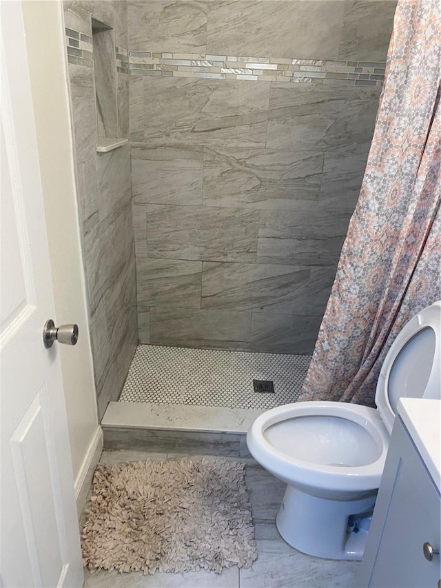 bathroom with walk in shower, toilet, and vanity