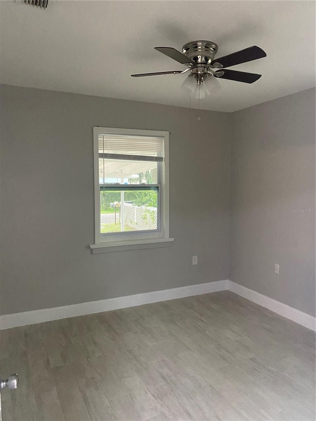 spare room with hardwood / wood-style floors and ceiling fan