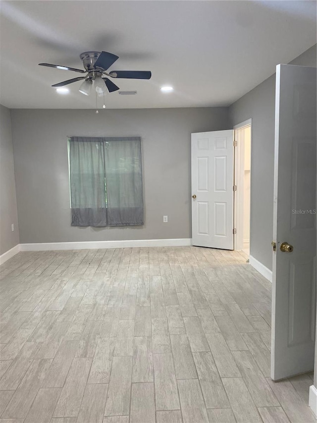 unfurnished room with light wood-type flooring and ceiling fan