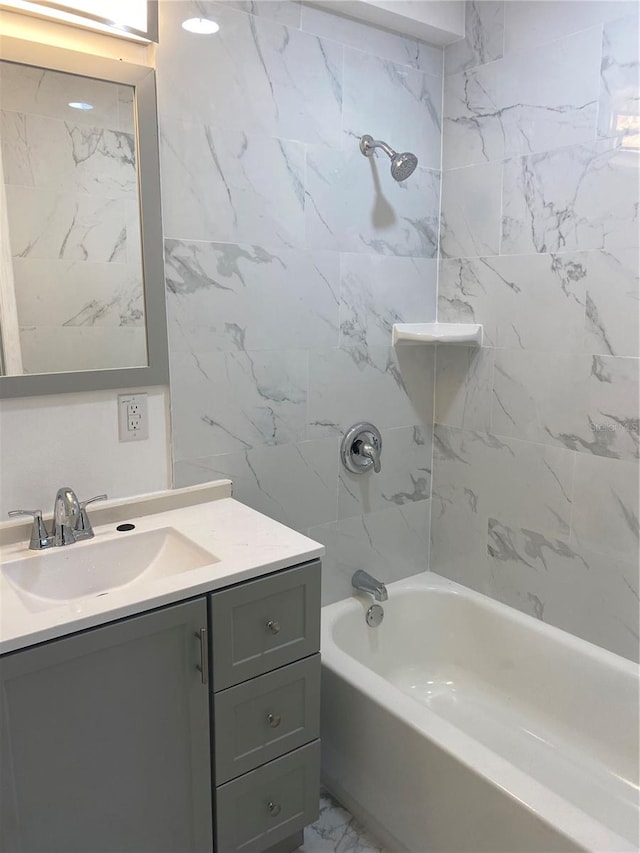 bathroom featuring tiled shower / bath combo and vanity