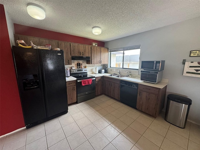 kitchen featuring light tile patterned floors, sink, black appliances, dark brown cabinets, and a textured ceiling