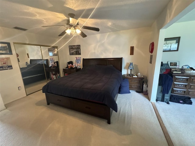 carpeted bedroom featuring ceiling fan and a textured ceiling