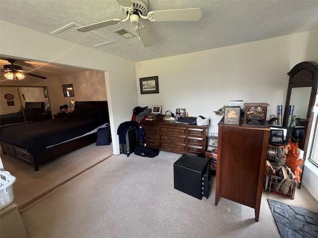 carpeted bedroom featuring a textured ceiling and ceiling fan