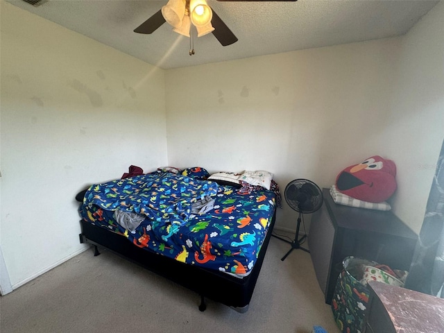 carpeted bedroom with a textured ceiling and ceiling fan