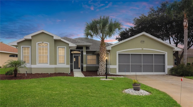 ranch-style house with a garage and a lawn